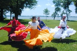 Hispanic dancers twirling colorful skirts in a park in Storm Lake