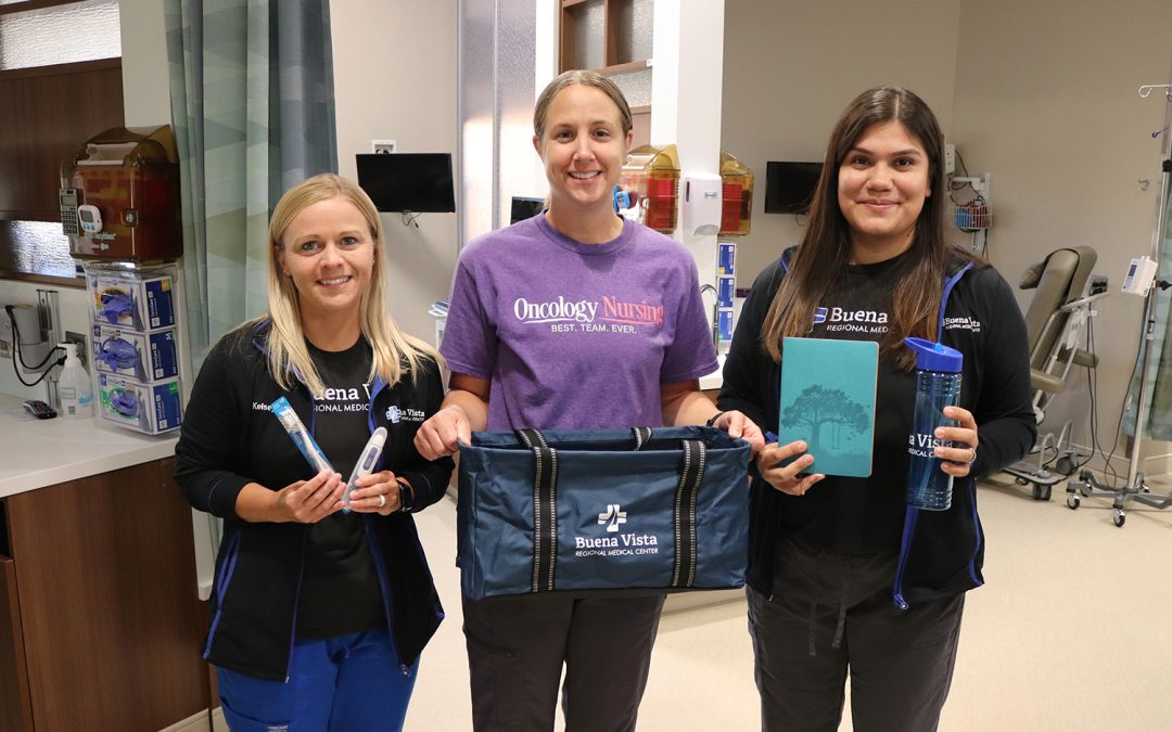Three BVRMC nursing holding the comfort bags and items in the bags, including a toothbrush, thermometer, notebook and water bottle.