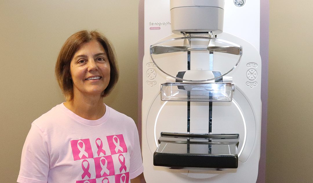 Julie White in a pink shirt is pictured next to BVRMC’s 3D mammography at BVRMC