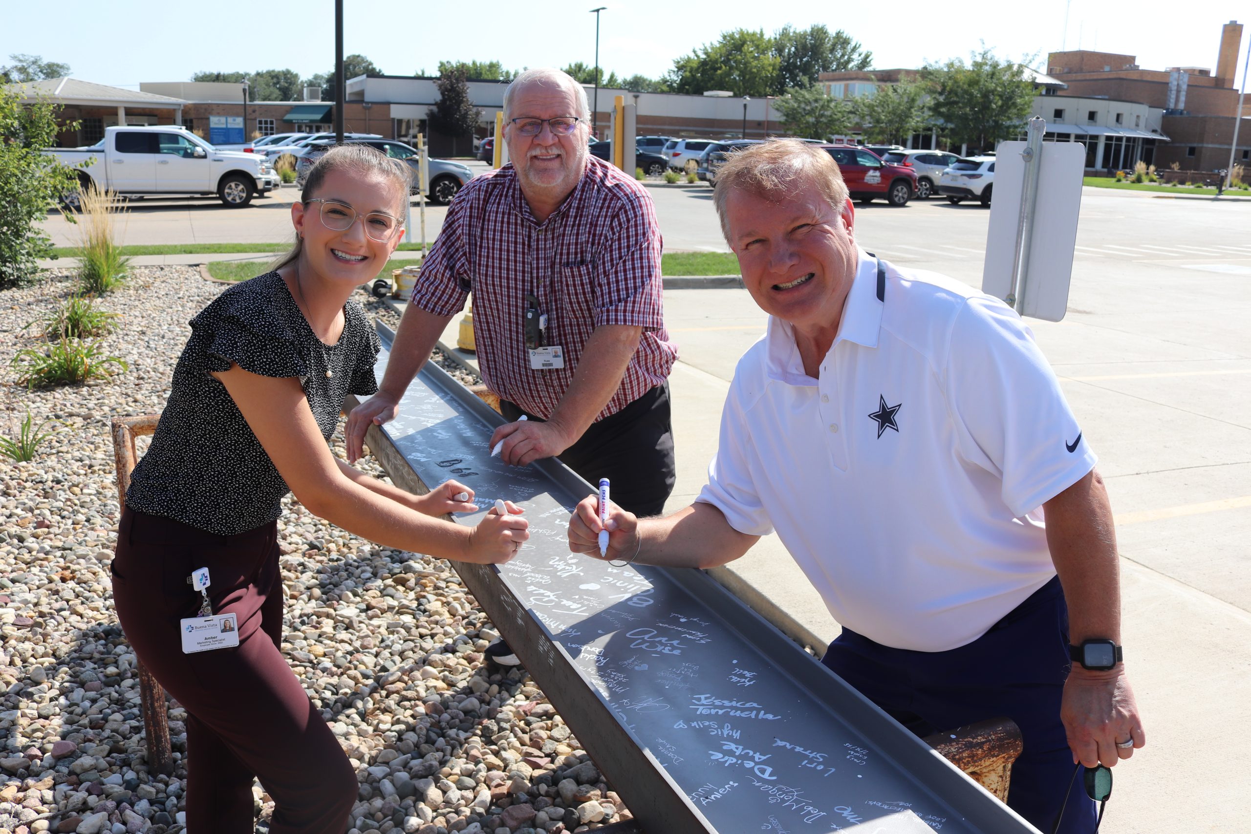 Employees signing a construction beam